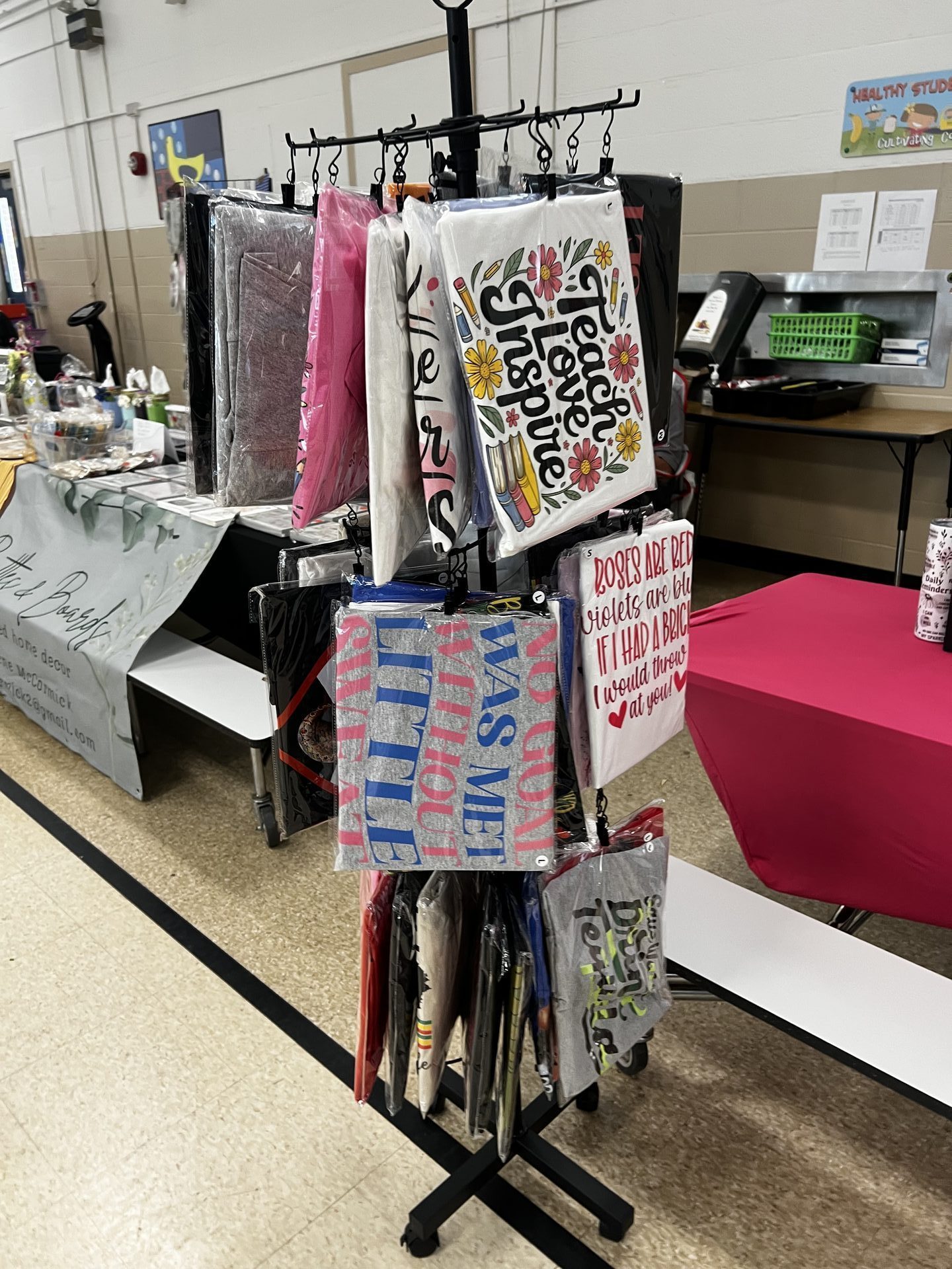Lashea Creative Studio vendor display rack with custom graphic tshirts
