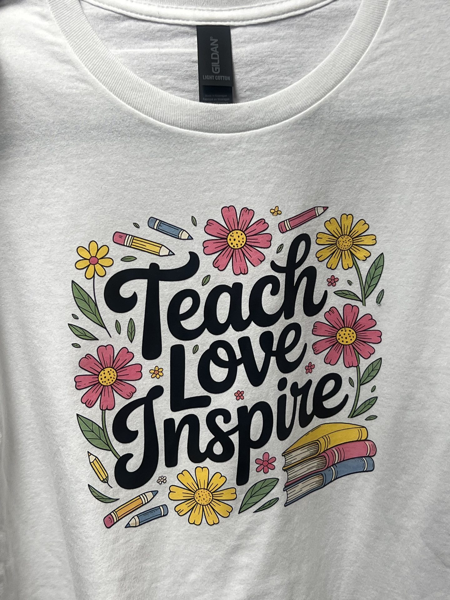 Custom white shirt with Teach Love Inspire script and floral design